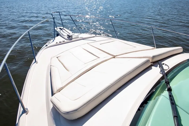 Slide: The Image of 2023 Grady-White Express 330 boat deck with sun pad on calm water. - 28