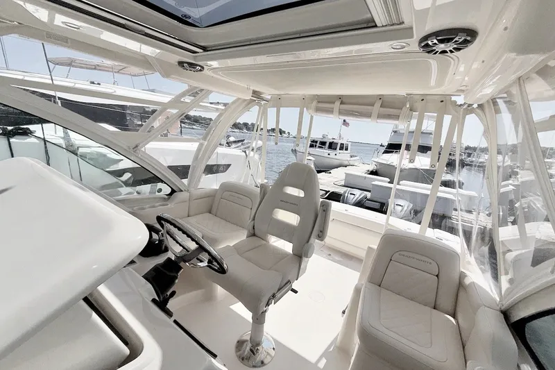 Slide: The Image of 2023 Grady-White Express 330 boat interior with helm, seating, and marina view. - 23