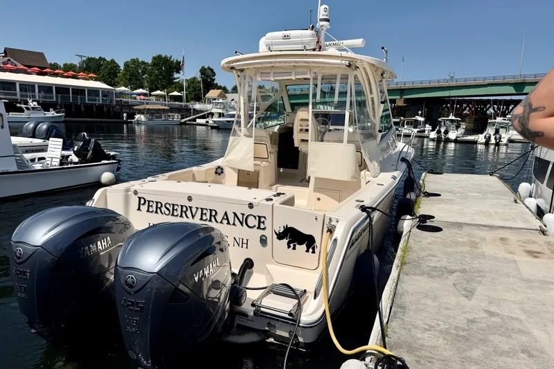 Slide: The Image of 2023 Grady-White Express 330 boat docked, featuring twin Yamaha engines. - 46