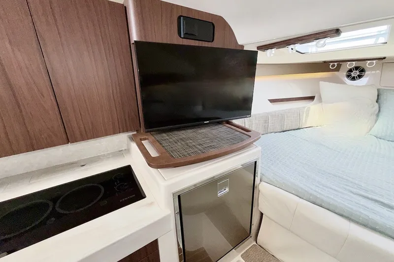 Slide: The Image of Interior of 2023 Grady-White Express 330 boat with TV, kitchenette, and cozy bed. - 8