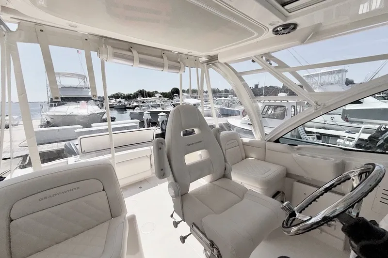 Slide: The Image of 2023 Grady-White Express 330 boat interior with luxurious seating at a marina. - 22