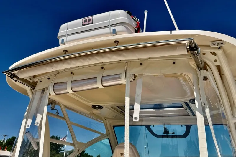 Slide: The Image of 2023 Grady-White Express 330 boat with clear enclosure and rooftop storage under a blue sky. - 32