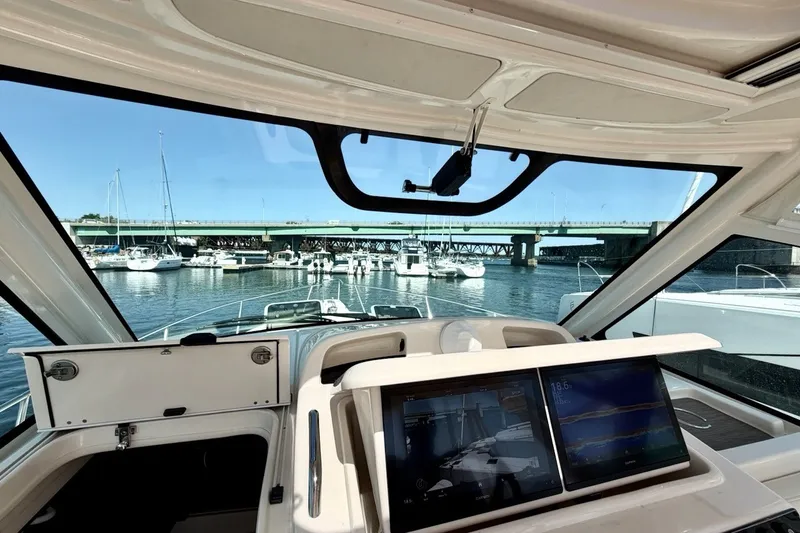 Slide: The Image of Interior view of 2023 Grady-White Express 330 boat with navigation screens and marina backdrop. - 18