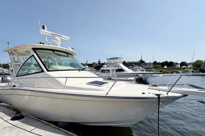 Slide: The Image of 2023 Grady-White Express 330 boat docked at a marina under clear blue skies. - 47