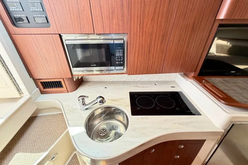 Slide: The Image of 2023 Grady-White Express 330 boat kitchen with sink, stove, and microwave. - 6