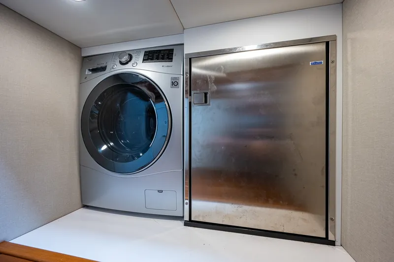 Slide: The Image of Laundry area in 2021 Palm Beach Motor Yachts PB55 with washer and stainless steel door. - 37