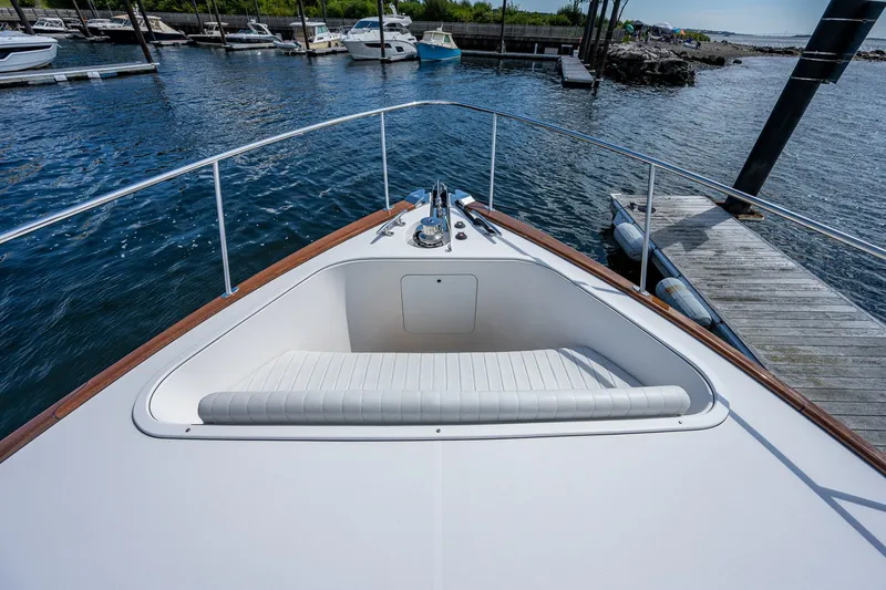 Slide: The Image of 2021 Palm Beach Motor Yachts PB55 bow view at marina, featuring sleek design and seating. - 14