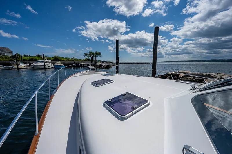 Slide: The Image of 2021 Palm Beach Motor Yachts PB55 on calm waters under a partly cloudy sky. - 13