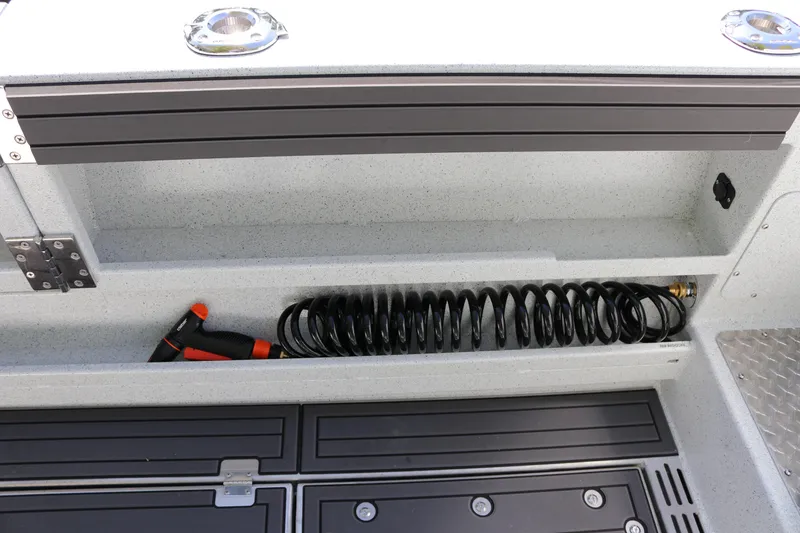Slide: The Image of Storage compartment with hose and nozzle on 2026 KingFisher 3425 GFX Offshore boat. - 33