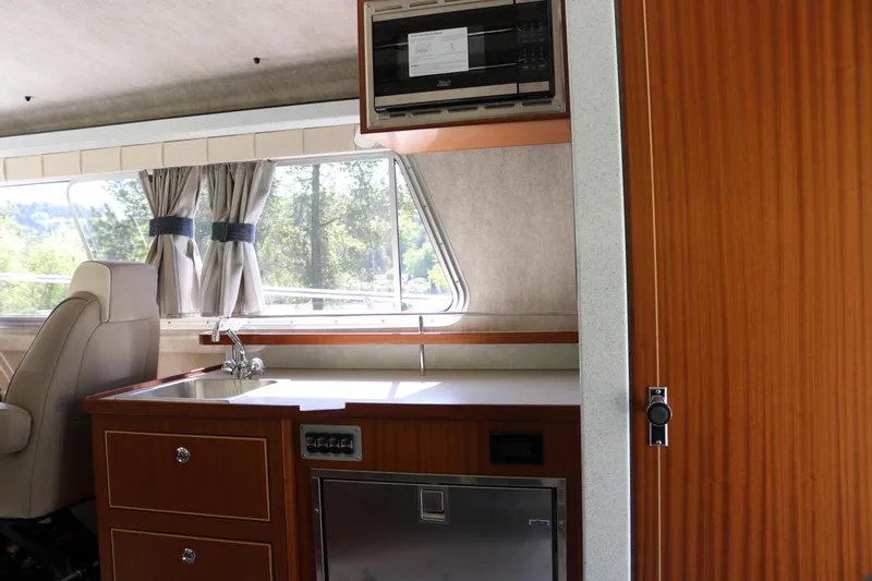 Slide: The Image of Interior of 2026 KingFisher 3425 GFX Offshore boat with kitchenette and window view. - 14