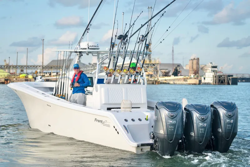The Image of 2025 Front Runner 36 Center Console boat with triple engines, docked in a marina. - 1