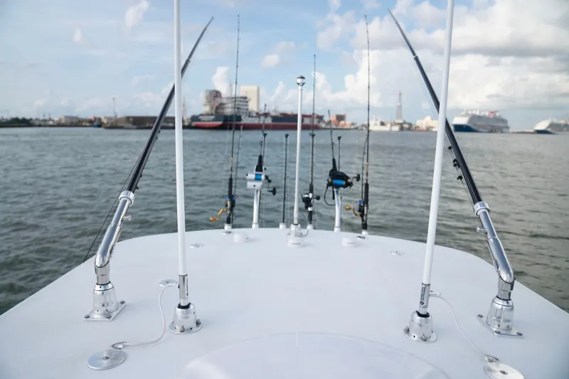Slide: The Image of 2025 Front Runner 36 Center Console with fishing rods on deck, cruising in a harbor. - 16