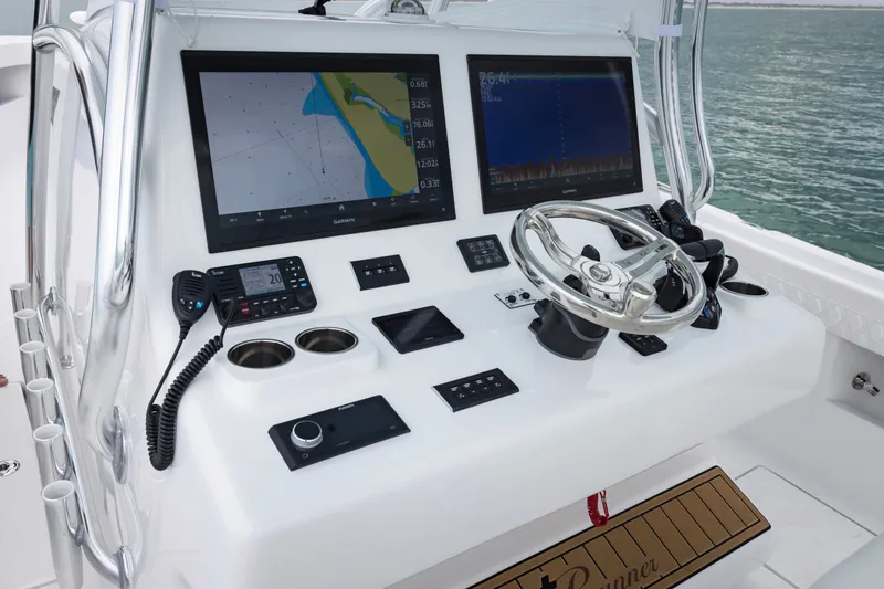 Slide: The Image of 2025 Front Runner 36 Center Console boat dashboard with dual Garmin displays and steering wheel. - 6