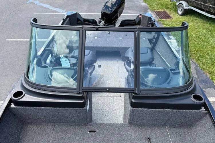 Slide: The Image of 2026 Crestliner 1650 Kodiak WT boat with windshield and seating, parked on pavement. - 8