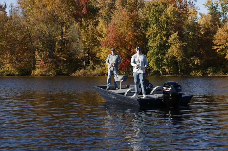 Slide: The Image of Two people fishing on a 2026 Smoker Craft Viper XR 165 boat in autumn scenery. - 2