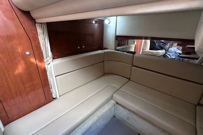 Slide: The Image of Interior of 2007 Sea Ray Sundancer 320, featuring beige seating and wooden cabinetry. - 17