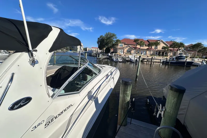 Slide: The Image of 2007 Sea Ray Sundancer 320 docked at a marina with waterfront homes in the background. - 3