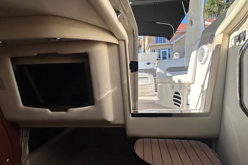 Slide: The Image of Interior view of 2007 Sea Ray Sundancer 320 yacht, featuring a TV and open cabin door. - 18