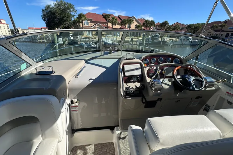 Slide: The Image of Cockpit view of a 2007 Sea Ray Sundancer 320, featuring steering wheel and navigation equipment. - 10