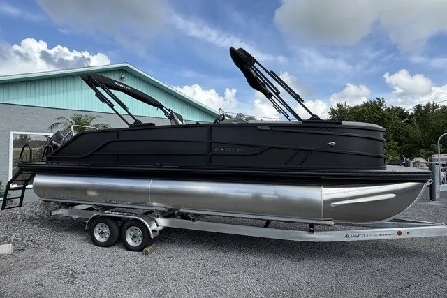 Slide: The Image of 2027 Evotti 523CS pontoon boat on trailer, parked outdoors under cloudy sky. - 11
