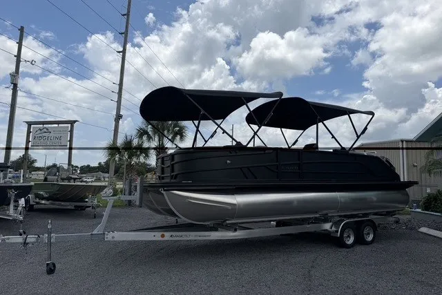 Slide: The Image of 2027 Evotti 523CS pontoon boat on trailer under cloudy sky. - 2