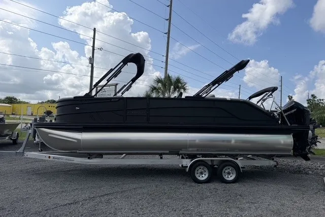 Slide: The Image of 2027 Evotti 523CS pontoon boat on trailer, sleek black design, parked outdoors. - 7
