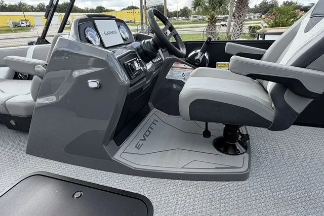 Slide: The Image of Captain's seat and dashboard of 2027 Evotti 523CS boat, featuring Garmin navigation system. - 23