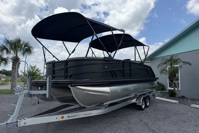 The Image of 2027 Evotti 523CS pontoon boat on trailer, featuring sleek black design and dual canopies. - 1