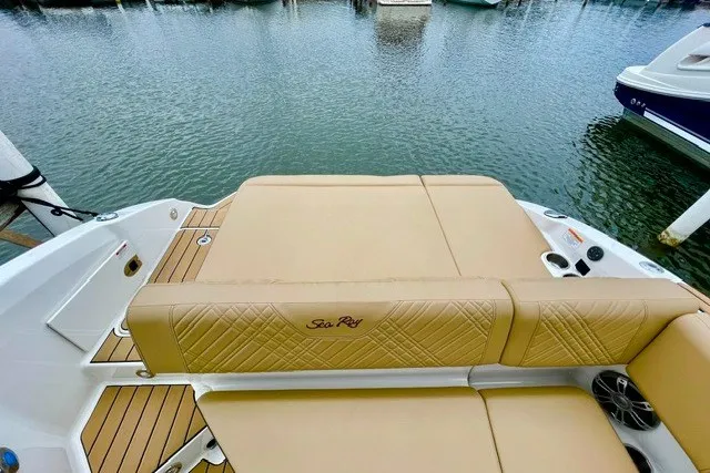 Slide: The Image of 2025 Sea Ray SDX 270 boat with tan seating, docked by the water. - 3