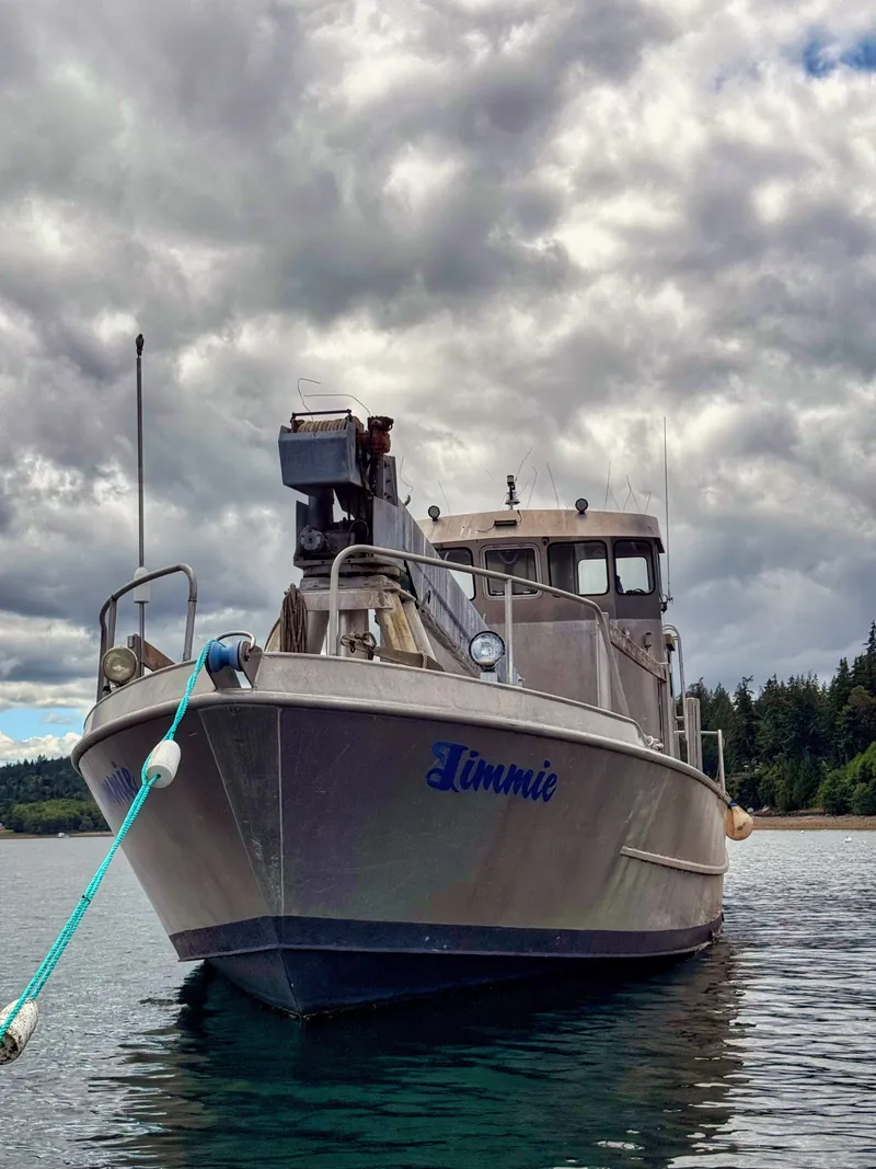 Slide: The Image of A sturdy aluminum boat named "Limmie" sits on calm water under a cloudy sky. - 21