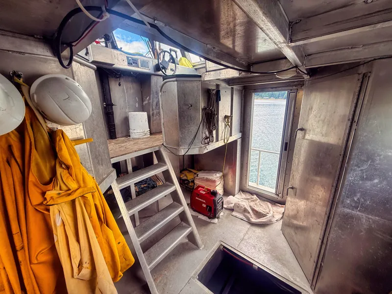 Slide: The Image of Interior of an aluminum boat with stairs, yellow jackets, and a view of the water. - 14