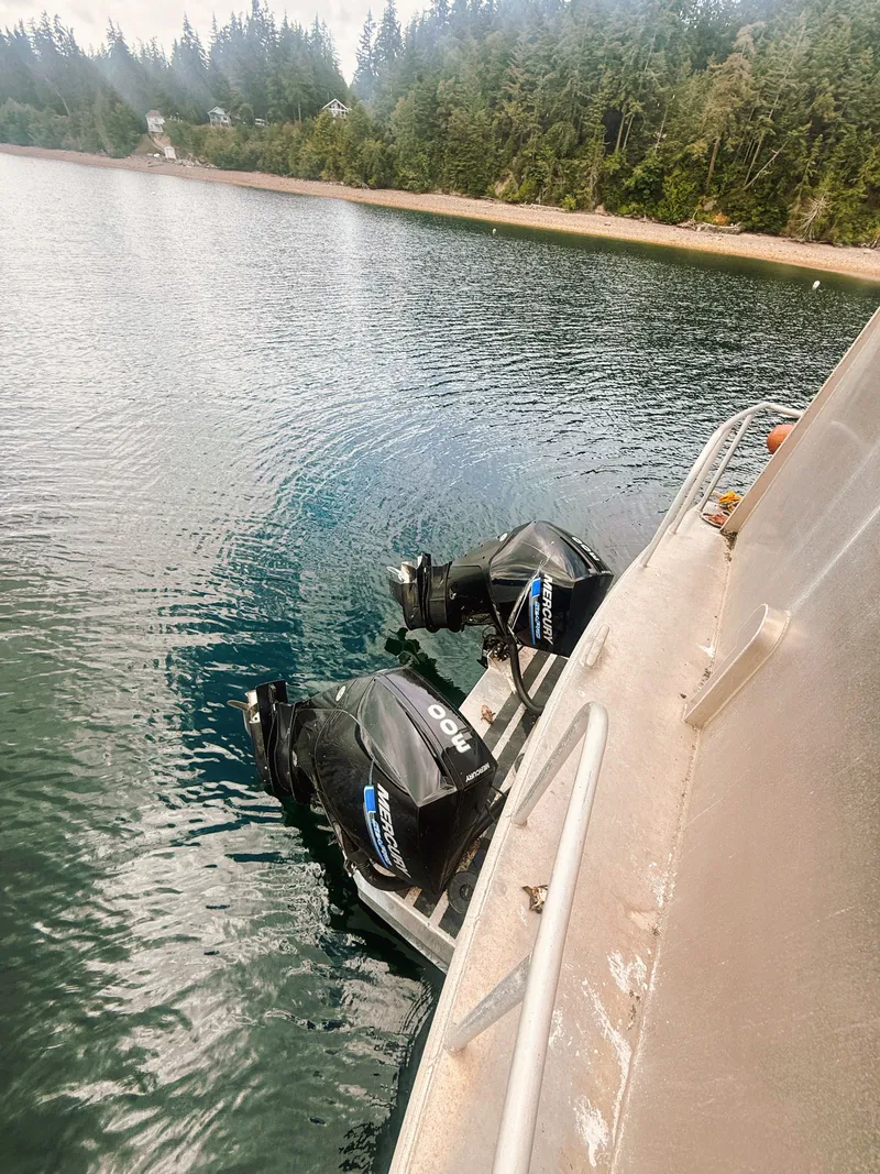 Slide: The Image of Two outboard motors are mounted on the stern of an aluminum boat in calm waters. - 4