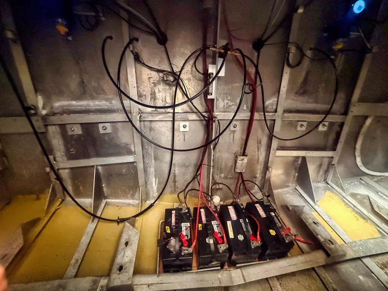 Slide: The Image of The engine room of a boat shows batteries and cables within an aluminum frame. - 9