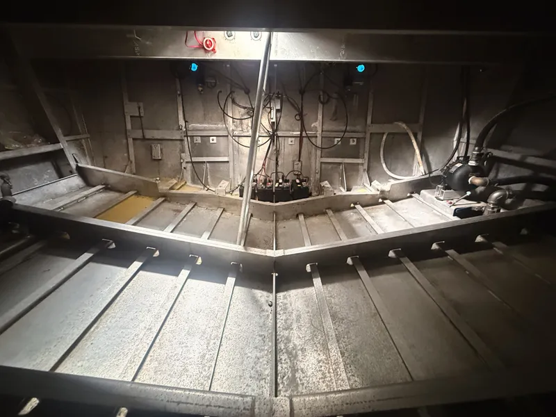 Slide: The Image of Interior view of an aluminum boat with visible wiring and pipes, built in 1997. - 13