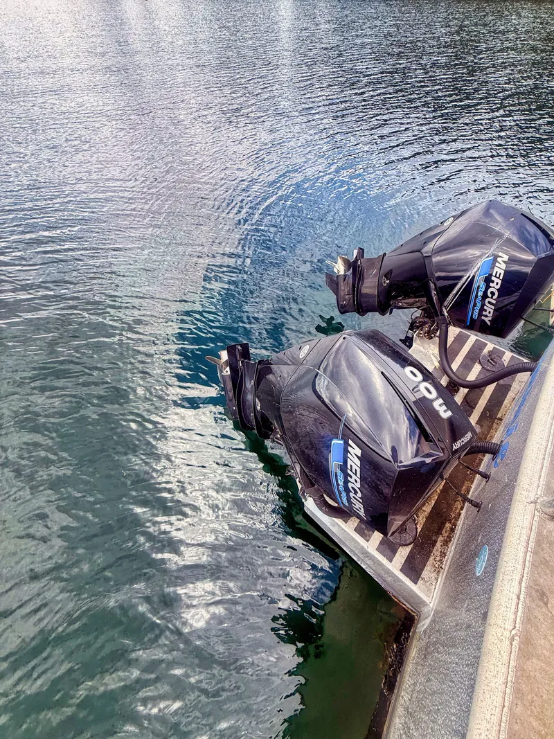 Slide: The Image of Two Mercury outboard motors are mounted on the stern of a boat in the water. - 5