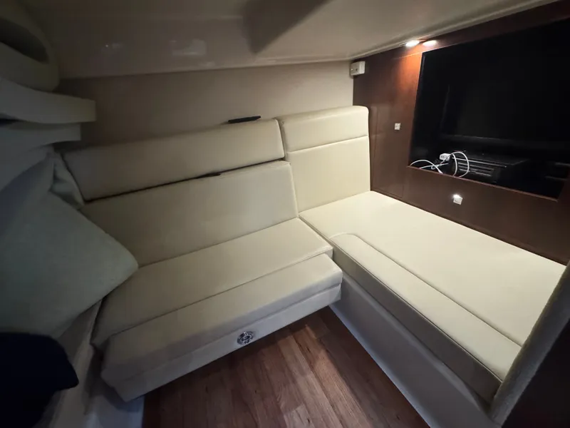 Slide: The Image of The image shows a cozy cabin with beige upholstery and a built-in television. - 14