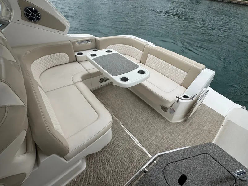 Slide: The Image of The image shows the seating area of a 2018 Chaparral 330 Signature boat with beige upholstery. - 5