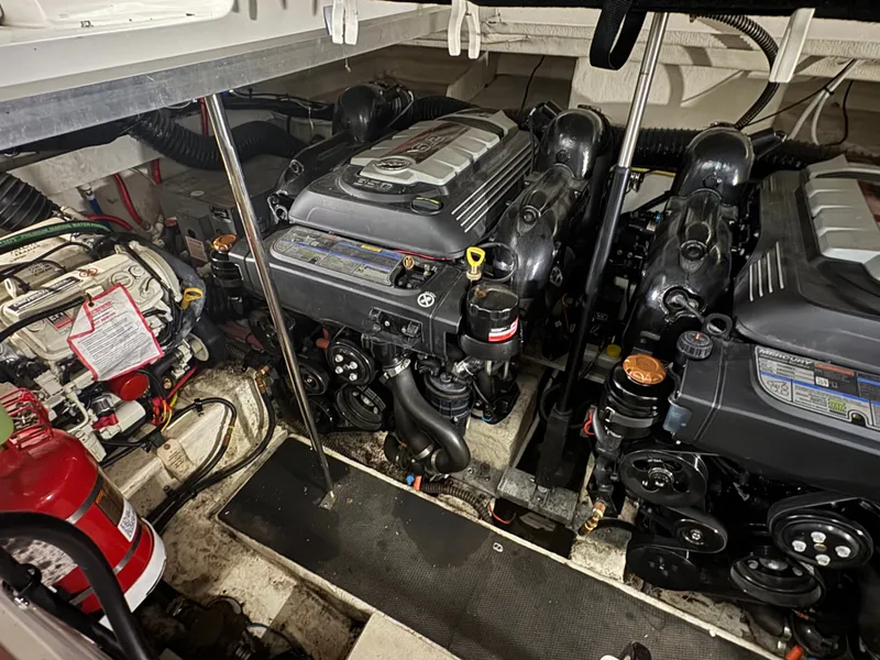 Slide: The Image of The engine room of a 2018 Chaparral 330 Signature with two large engines and a fire extinguisher. - 16