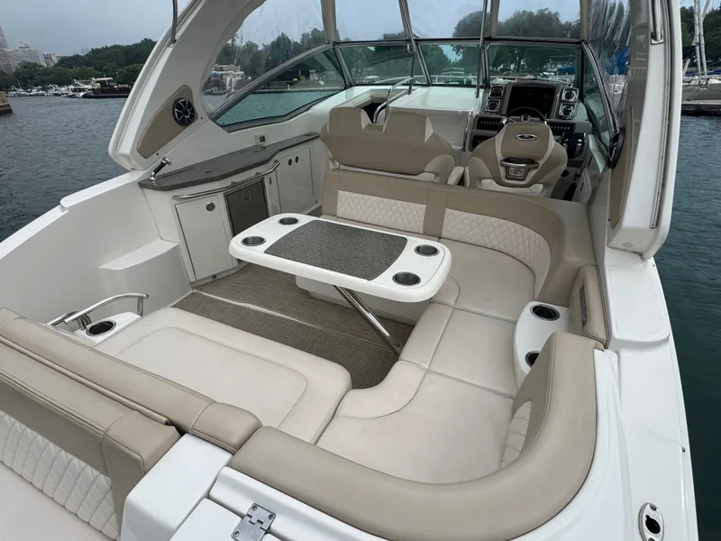 Slide: The Image of The image shows the cockpit of a 2018 Chaparral 330 Signature with beige seating and a table. - 3