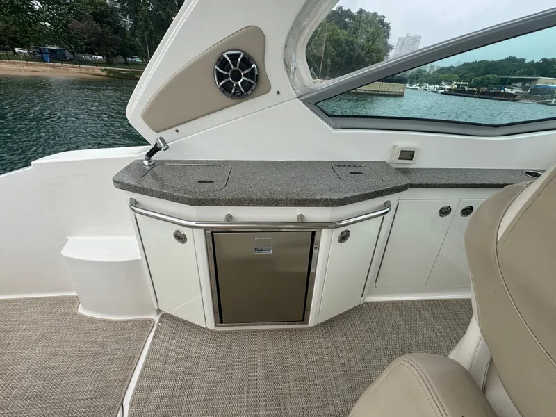 Slide: The Image of The image shows the cockpit of a 2018 Chaparral 330 Signature with a small kitchenette. - 7
