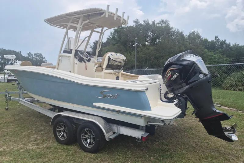 The Image of 2017 Scout 215 XSF boat on trailer with Yamaha outboard motor, parked on grass. - 0