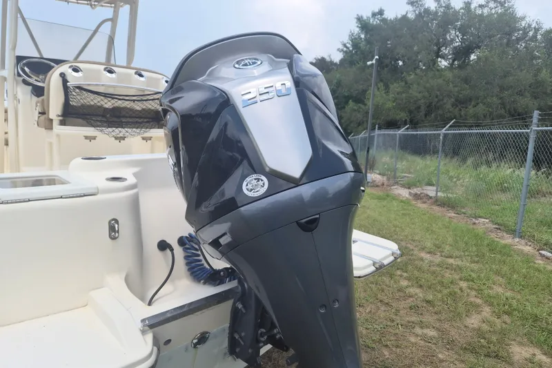 Slide: The Image of 2017 Scout 215 XSF boat with a 250 horsepower outboard motor, parked on grass. - 3