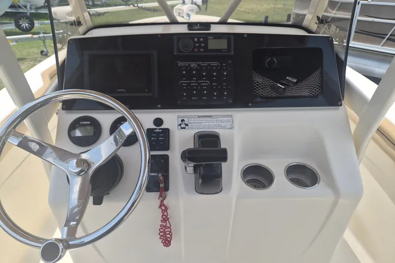 Slide: The Image of 2017 Scout 215 XSF boat dashboard with steering wheel, controls, and cup holders. - 16