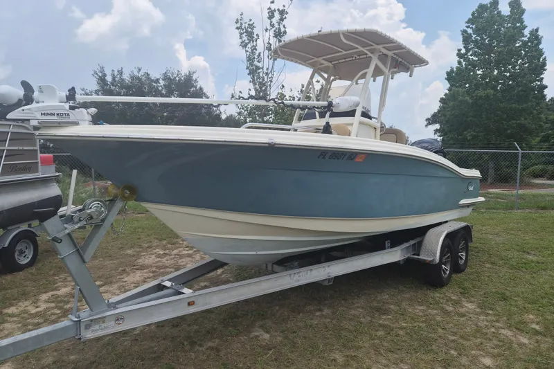 Slide: The Image of 2017 Scout 215 XSF boat on trailer, parked outdoors under cloudy sky. - 1