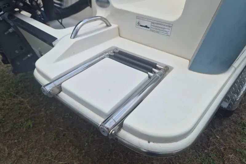 Slide: The Image of 2017 Scout 215 XSF boat swim platform with foldable ladder on grass. - 5