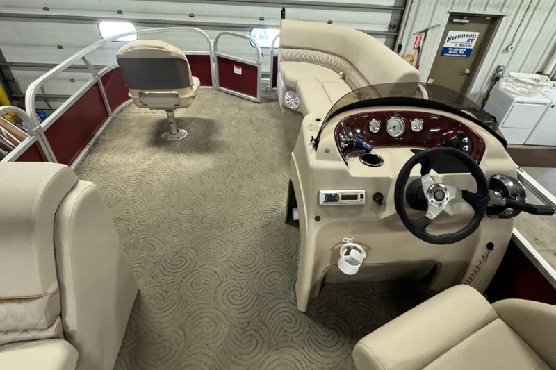 Slide: The Image of 2014 Sun Tracker Party Barge 20 DLX interior with helm, seating, and carpeted floor. - 15