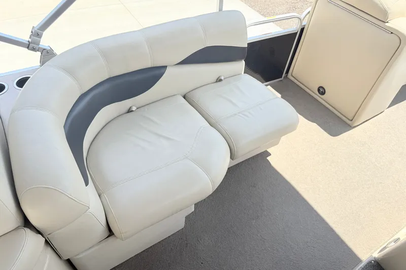 Slide: The Image of 2013 AquaPatio 240 RS boat interior with beige seating and cup holders. - 6