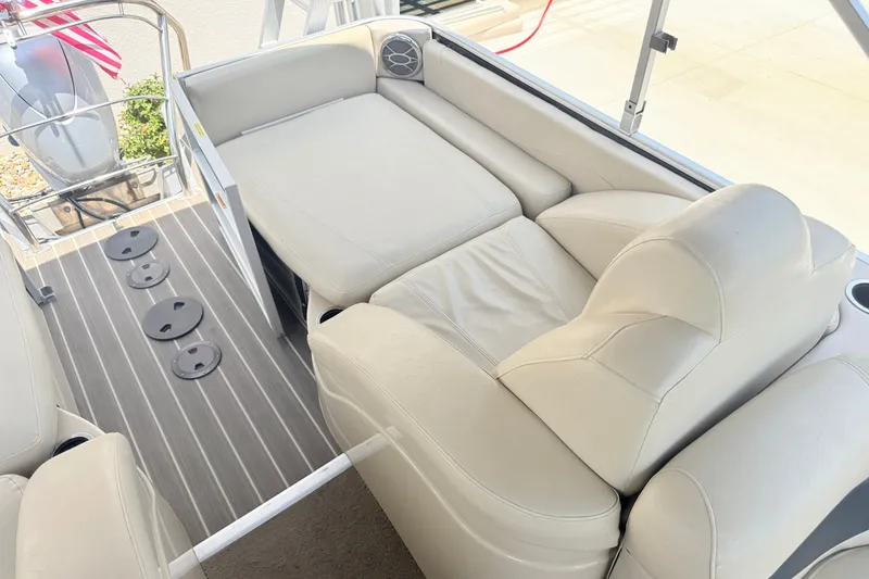 Slide: The Image of 2013 AquaPatio 240 RS boat interior with beige seating and striped flooring. - 13