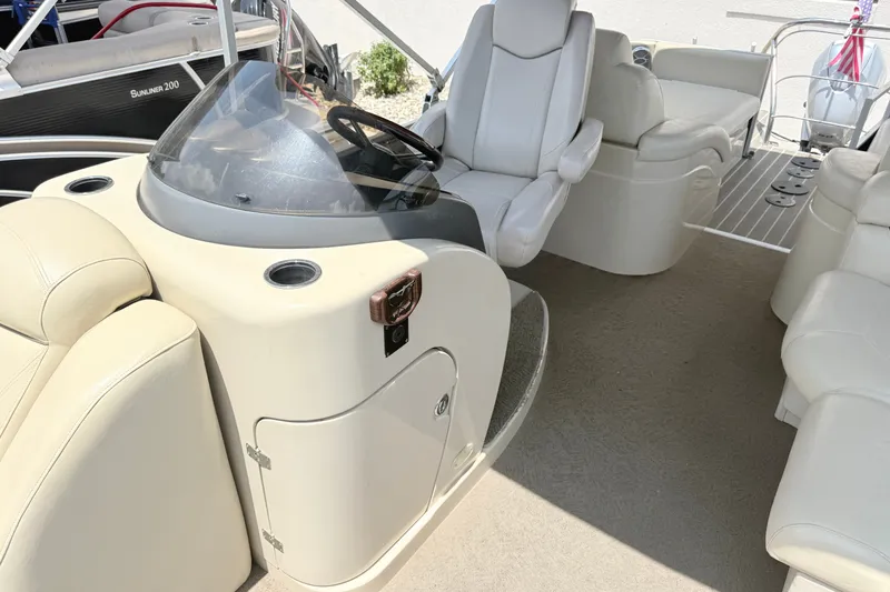 Slide: The Image of Interior of a 2013 AquaPatio 240 RS boat with white seating and steering console. - 14