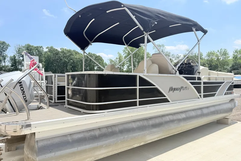 Slide: The Image of 2013 AquaPatio 240 RS pontoon boat with canopy, docked outdoors. - 3